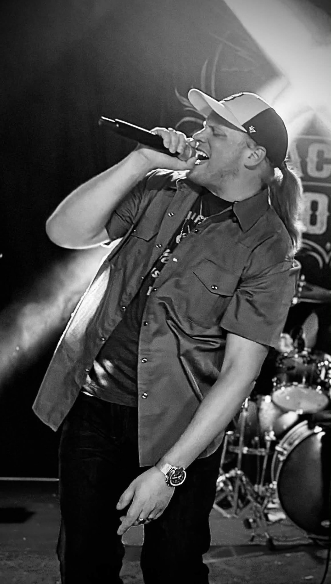 Lead singer belting into the microphone, black and white