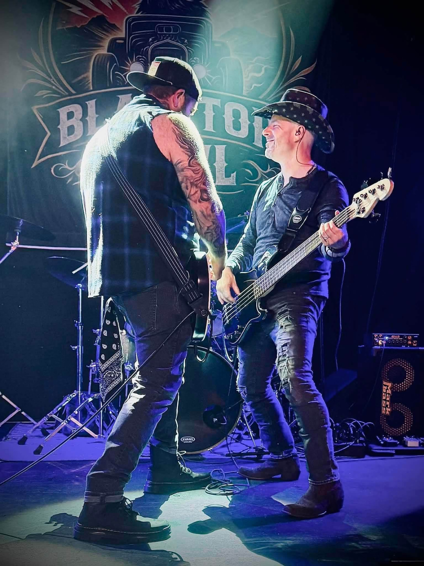 Guitarist and bassist facing off on stage